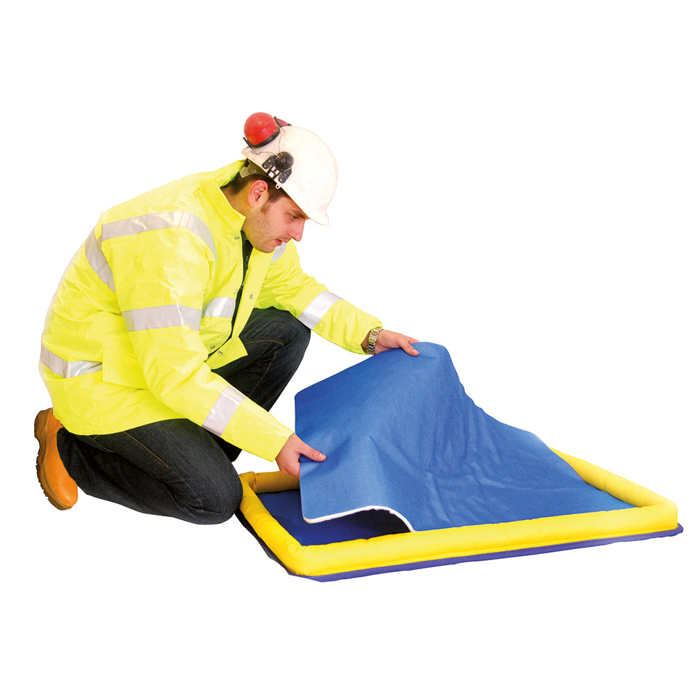 Person in a high-visibility jacket setting up an inflatable slide with a blue cover on a white background